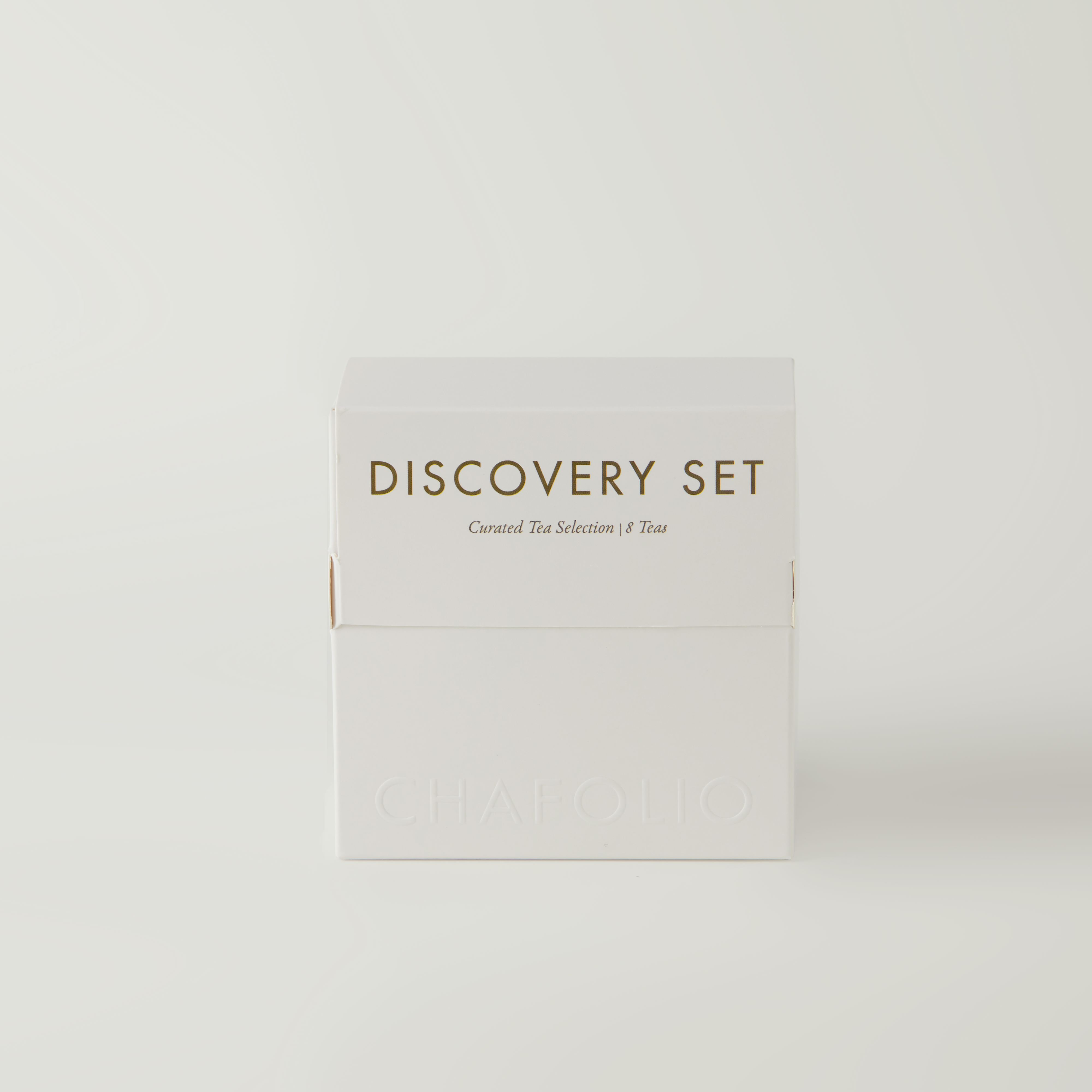 A white box labeled "Discovery Set | Curated Tea Selection" from Chafolio rests on a plain background, promising curated delights such as Oolong Tea and Jasmine Green Tea. The brand name "Chafolio" appears embossed at the bottom.